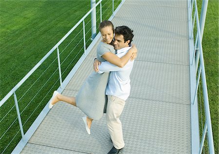 simsearch:695-03389116,k - Couple on walkway, man spinning woman around in his arms Foto de stock - Royalty Free Premium, Número: 695-03374861