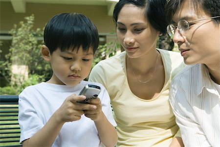 simsearch:696-03401224,k - Family, boy using cell phone while parents watch Stock Photo - Premium Royalty-Free, Code: 695-03374908