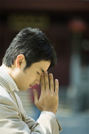 Young man praying Stock Photo - Premium Royalty-Free, Code: 695-03375055