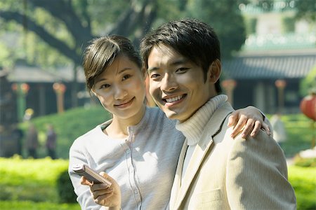 simsearch:696-03401266,k - Young couple with cell phone, smiling at camera, portrait Fotografie stock - Premium Royalty-Free, Codice: 695-03375062