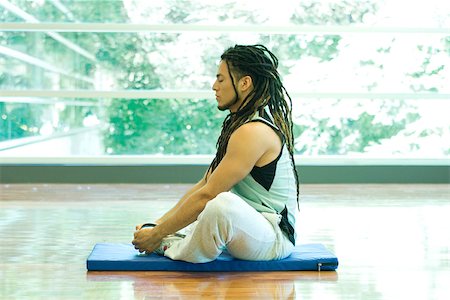 Man sitting in lotus position, side view Stock Photo - Premium Royalty-Free, Code: 695-03375089