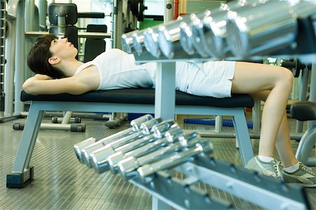 simsearch:695-03375202,k - Woman lying on weight bench, doing sit-ups Stock Photo - Premium Royalty-Free, Code: 695-03375180