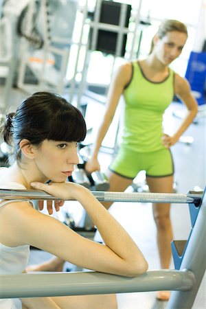 simsearch:695-03375202,k - Woman sitting in weight room, holding on to metal bar, looking away Stock Photo - Premium Royalty-Free, Code: 695-03375199