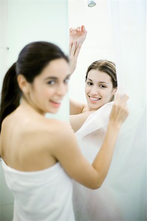 Woman holding shower curtain open where friend is taking shower Fotografie stock - Premium Royalty-Free, Codice: 695-03375237