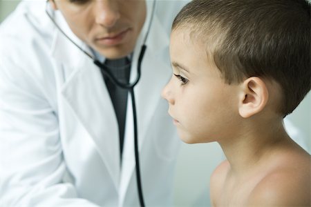 doctor listening boy - Doctor leaning toward boy with stethoscope Stock Photo - Premium Royalty-Free, Code: 695-03375276