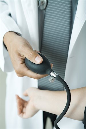 Doctor taking woman's blood pressure, close-up Foto de stock - Sin royalties Premium, Código: 695-03375279