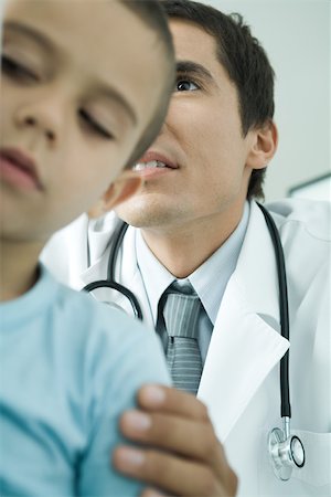 pediatric doctor boy exam - Boy and doctor, doctor holding boy's shoulder, low angle view Stock Photo - Premium Royalty-Free, Code: 695-03375273