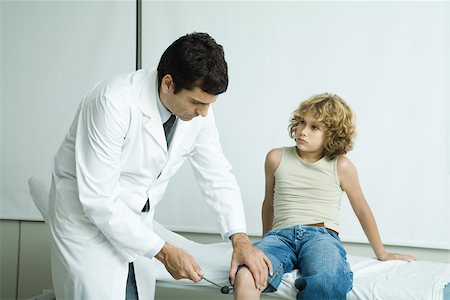 paediatrician (male) - Doctor checking boy's reflexes Stock Photo - Premium Royalty-Free, Code: 695-03375286