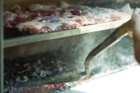 simsearch:695-03375495,k - Meats grilling in wood oven, person shoveling ashes Foto de stock - Sin royalties Premium, Código: 695-03375509