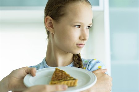 reject food - Girl turning head from plate of quiche being held up Stock Photo - Premium Royalty-Free, Code: 695-03375538