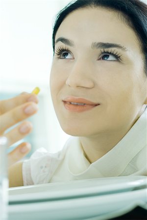 simsearch:695-05769743,k - Woman holding up vitamin, looking up Stock Photo - Premium Royalty-Free, Code: 695-03375532