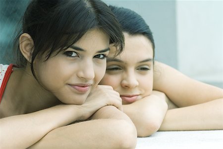 simsearch:632-01277233,k - Teen girl and young woman resting heads on arms, smiling Fotografie stock - Premium Royalty-Free, Codice: 695-03375689
