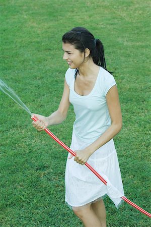 Young woman holding garden hose Stock Photo - Premium Royalty-Free, Code: 695-03375724