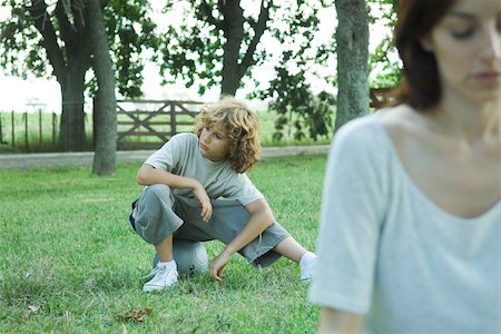 Boy sitting on ball, mother in foreground Stock Photo - Premium Royalty-Free, Code: 695-03375844