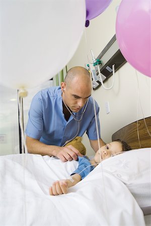 Girl lying in hospital bed, surrounded by balloons Stock Photo - Premium Royalty-Free, Code: 695-03375872