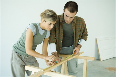 Couple, effectuer des mesures sur planche de bois Photographie de stock - Premium Libres de Droits, Code: 695-03376049