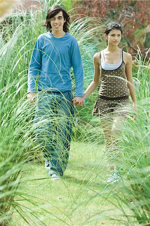 Young couple walking through long grasses of ornamental garden Stock Photo - Premium Royalty-Free, Code: 695-03376064
