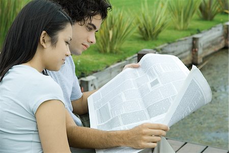 Young couple reading newspaper together outdoors Stock Photo - Premium Royalty-Free, Code: 695-03376072