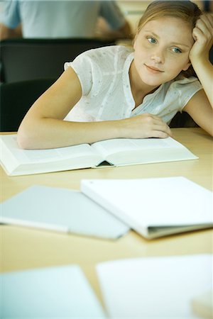 simsearch:632-01380712,k - Young woman studying in university library, leaning on book and looking away Fotografie stock - Premium Royalty-Free, Codice: 695-03376128