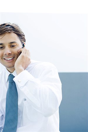 simsearch:632-02745019,k - Young businessman using cell phone, smiling, cropped view Stock Photo - Premium Royalty-Free, Code: 695-03376252