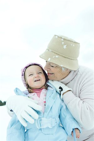 Grandmother embracing toddler in snow, both smiling Stock Photo - Premium Royalty-Free, Code: 695-03376289