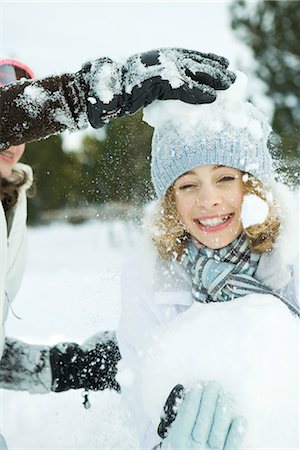 simsearch:695-03375570,k - Adolescente se faire frapper avec des boules de neige, souriant à la caméra Photographie de stock - Premium Libres de Droits, Code: 695-03376302
