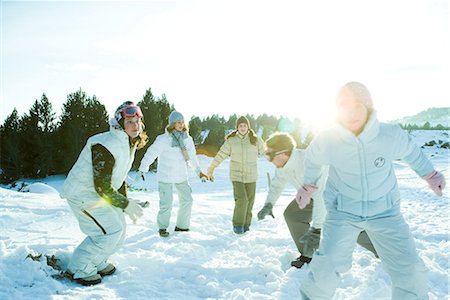 Young friends running in snow, dressed in winter clothing Foto de stock - Sin royalties Premium, Código: 695-03376310