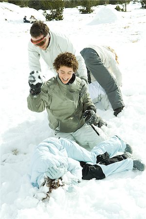 simsearch:632-01613222,k - Young friends having snowball fight, one lying on ground, covering head with arms Stock Photo - Premium Royalty-Free, Code: 695-03376322