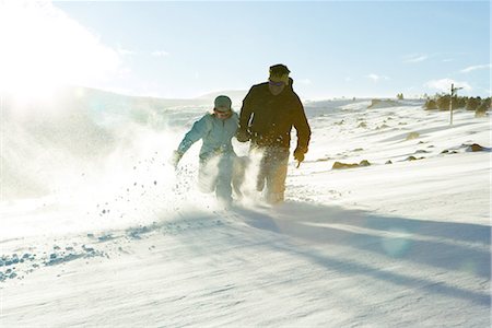 Father and daughter running in snow together, full length Stock Photo - Premium Royalty-Free, Code: 695-03376335