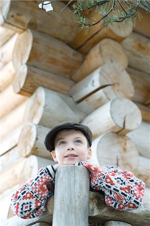 Boy standing on deck of wood cabin, leaning on rail Stock Photo - Premium Royalty-Free, Code: 695-03376359