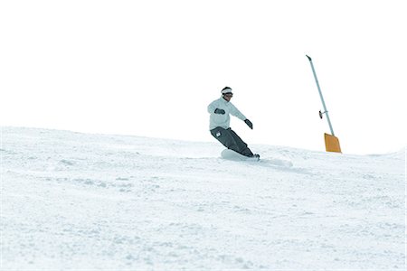 simsearch:695-03376454,k - Jeune homme snowboard vers le bas de la pente de ski, pleine longueur Photographie de stock - Premium Libres de Droits, Code: 695-03376480