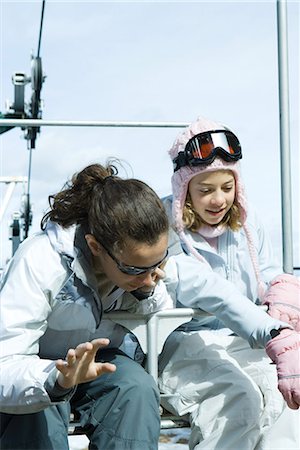 simsearch:632-01613222,k - Two teenage girls sitting on chair lift together, looking over side Stock Photo - Premium Royalty-Free, Code: 695-03376496