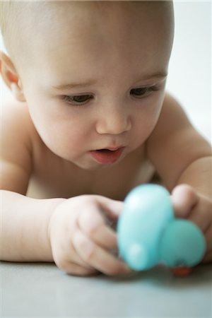 simsearch:632-01613298,k - Baby lying on floor, holding toy, close-up Foto de stock - Royalty Free Premium, Número: 695-03376607