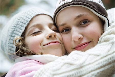 simsearch:695-03389357,k - Two sisters embracing, smiling, one closing eyes, the other looking at camera, portrait Stock Photo - Premium Royalty-Free, Code: 695-03376877