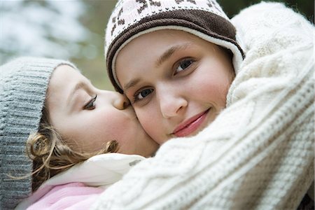 simsearch:695-03389357,k - Teenage girl smiling at camera, sister kissing her on cheek, portrait Stock Photo - Premium Royalty-Free, Code: 695-03376888