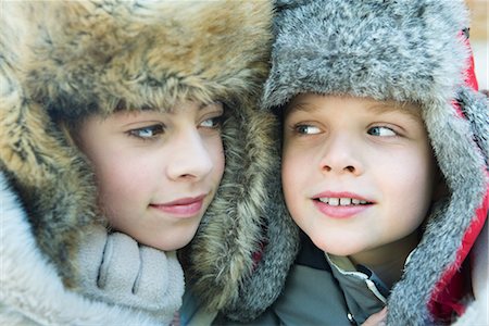 furry preteen - Sister and brother wearing fur caps, smiling at each other, portrait Stock Photo - Premium Royalty-Free, Code: 695-03376880