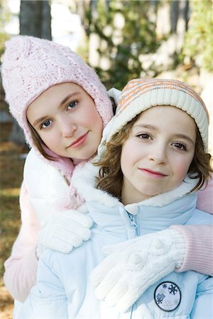 simsearch:695-03389357,k - Two young friends smiling at camera, wearing knit hats, one's arm around the other's shoulder, portrait Stock Photo - Premium Royalty-Free, Code: 695-03376890