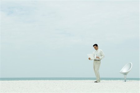 simsearch:633-01713826,k - Businessman standing on beach, looking at laptop computer, full length Stock Photo - Premium Royalty-Free, Code: 695-03376962