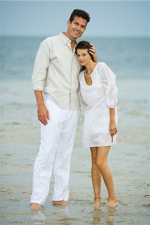 simsearch:695-05767093,k - Man and young female companion on beach, standing together, looking at camera, full length Fotografie stock - Premium Royalty-Free, Codice: 695-03376990