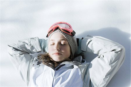 simsearch:633-01992734,k - Teenage girl lying on snow with hands behind head and eyes closed Foto de stock - Royalty Free Premium, Número: 695-03377025