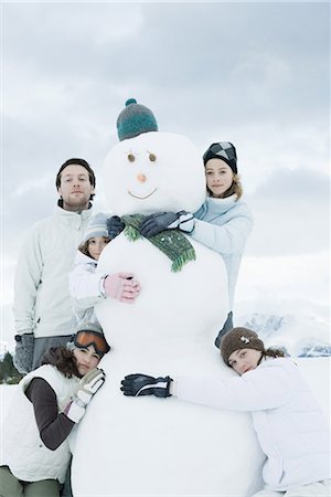 Young friends grouped around snowman, posing, portrait Stock Photo - Premium Royalty-Free, Code: 695-03377044