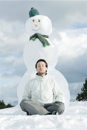 simsearch:695-03377027,k - Young man sitting with legs crossed and eyes closed in front of snowman Foto de stock - Sin royalties Premium, Código: 695-03377040