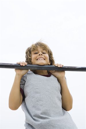 simsearch:632-01145012,k - Boy doing pull-up, chin resting on bar, smiling at camera Stock Photo - Premium Royalty-Free, Code: 695-03377180
