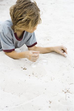 simsearch:695-03377206,k - Boy lying on the ground, arranging pebbles in sand Stock Photo - Premium Royalty-Free, Code: 695-03377192