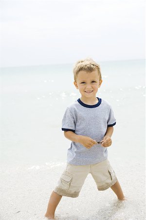 simsearch:695-03377221,k - Jeune garçon debout cheville profondément dans l'eau à la plage, souriant à la caméra Photographie de stock - Premium Libres de Droits, Code: 695-03377223