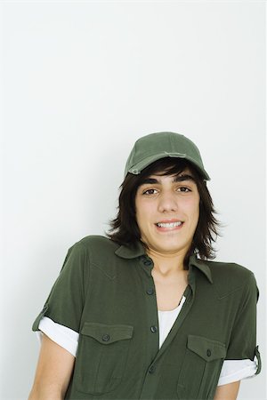 Teenage boy wearing baseball cap, biting lip, looking at camera Fotografie stock - Premium Royalty-Free, Codice: 695-03377389