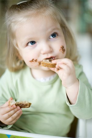 funny sweets - Blonde toddler girl eating bread with chocolate Stock Photo - Premium Royalty-Free, Code: 695-03377397