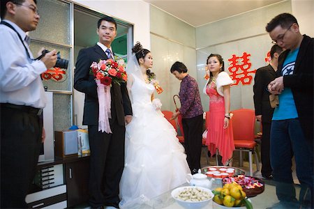 Chinese wedding, bride and groom standing, food and drink on table Stock Photo - Premium Royalty-Free, Code: 695-03377449