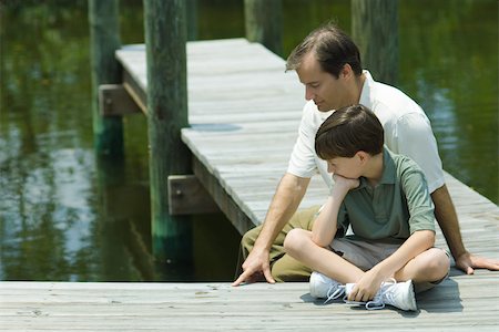 simsearch:649-07437981,k - Father and son sitting on dock, looking down together Stock Photo - Premium Royalty-Free, Code: 695-03377493