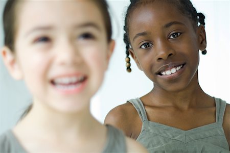 simsearch:632-01785132,k - Two girls smiling, one looking at camera, selective focus Foto de stock - Sin royalties Premium, Código: 695-03377517